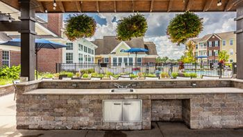 A patio with a grill and a view of a residential area
